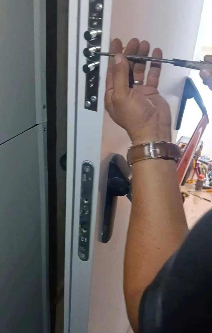 Técnico ajustando una cerradura en la puerta